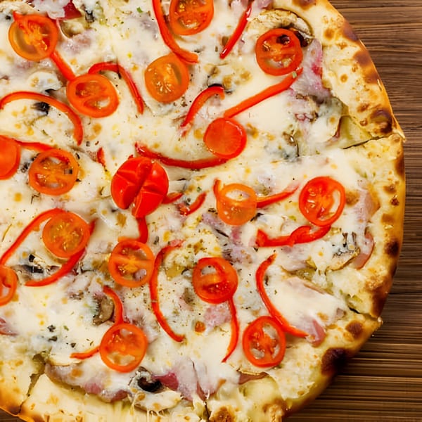 A Franco's Italian Restaurant pizza with melted cheese, red peppers, and cherry tomatoes on a wooden table.